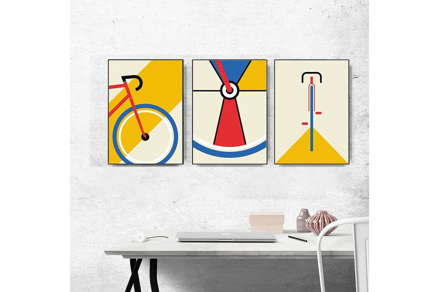 Triptychon Dreiteiliges Poster mit Fahrradmotiven an einer grauen Wand mit Schreibtisch davor.