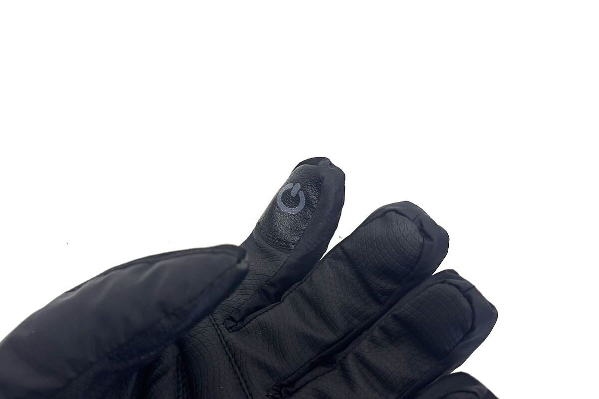 Schwarzer, gepolsterter Handschuh, dessen Zeigefinger eine Touchscreen-Markierung trägt.